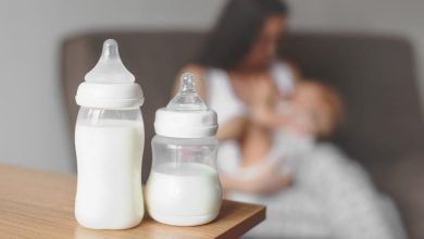 Assorted baby bottles suitable for breastfed babies, displayed on a nursery table