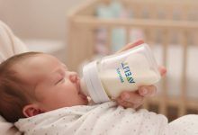 Newborn baby feeding from Philips Avent anti-colic bottle with AirFree vent technology