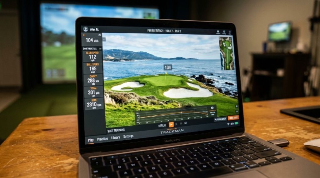 Close-up of a laptop screen showing TrackMan golf simulation software with a virtual golf course loaded