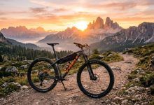 Modern aluminum mountain bike parked on mountain trail sunrise background.