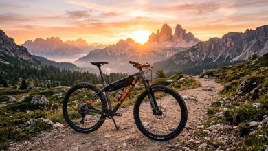 Modern aluminum mountain bike parked on mountain trail sunrise background.
