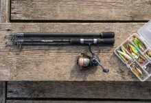 Beginner angler holding a Plusinno fishing rod combo by a scenic lake at sunset.